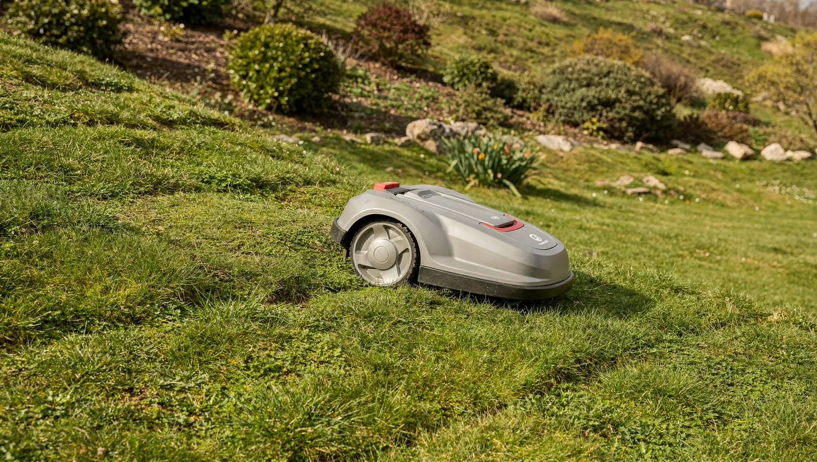 Robot tondeuse montant une pelouse en forte pente